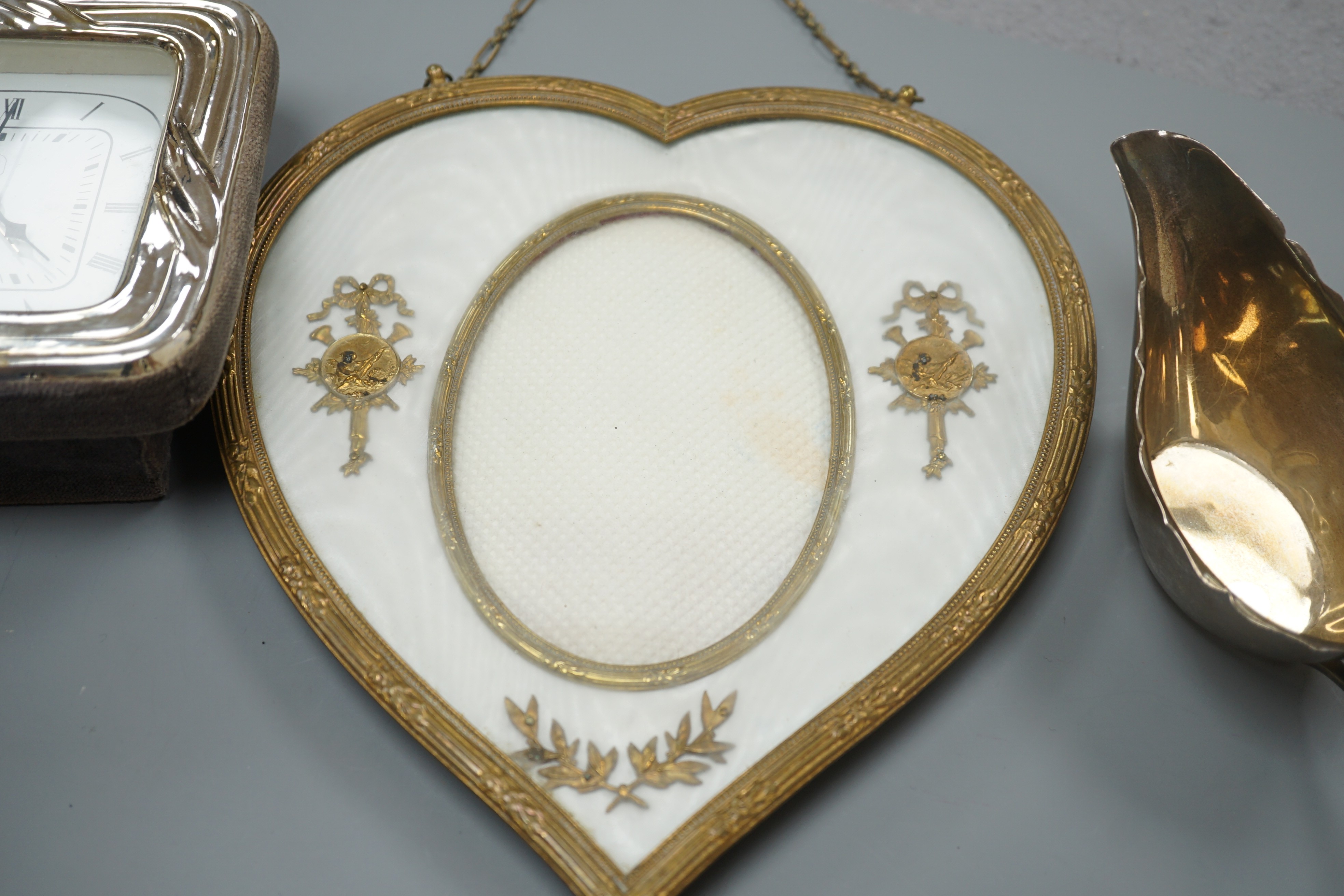 A 19th century gilt heart-shaped frame, A Japanese sterling figural spoon, a 1930's silver cream jug and modern silver mounted clock, photo frame 20 cms high.